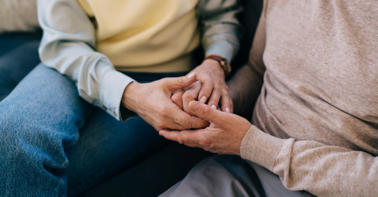 afbeelding van twee personen die elkaars hand vasthouden